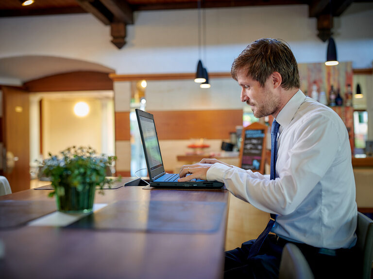 Gast schreibt im digitalen Gästebuch am Laptop im Ringhotel Gasthof Hasen in Herrenberg