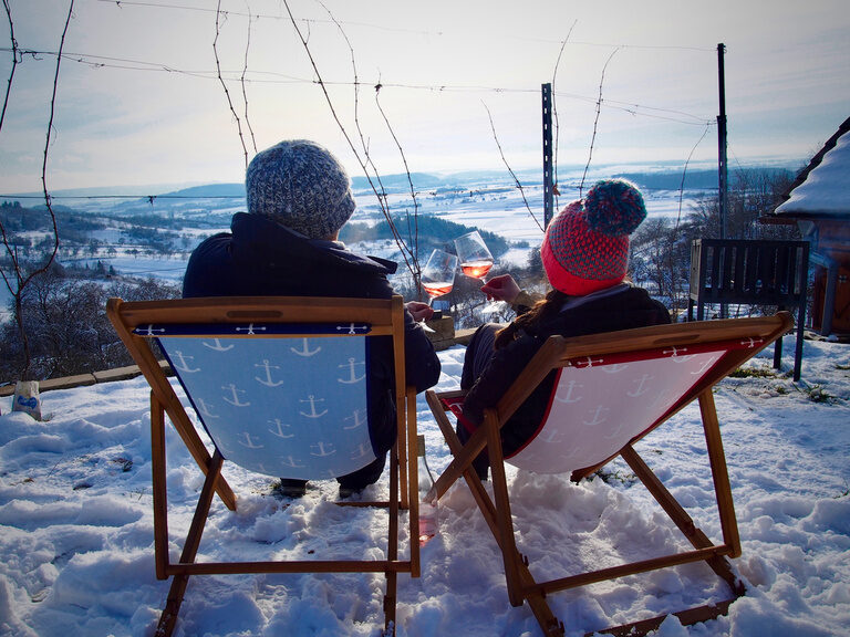 Gäste genießen Wein mit Blick über den winterlichen Weinberg bei Herrenberg im Naturpark Schönbuch