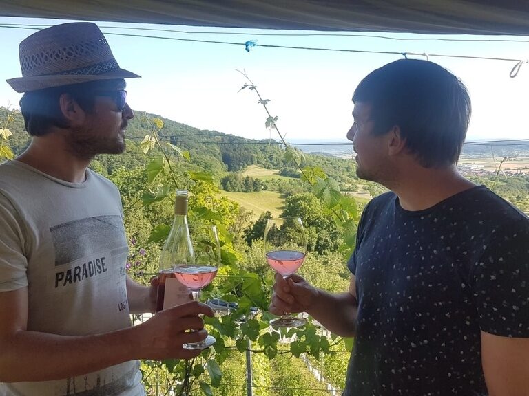 Zwei Männer verkosten Roséwein im Weinberg des Ringhotel Gasthof Hasen in Herrenberg mit Blick über den Naturpark Schönbuch