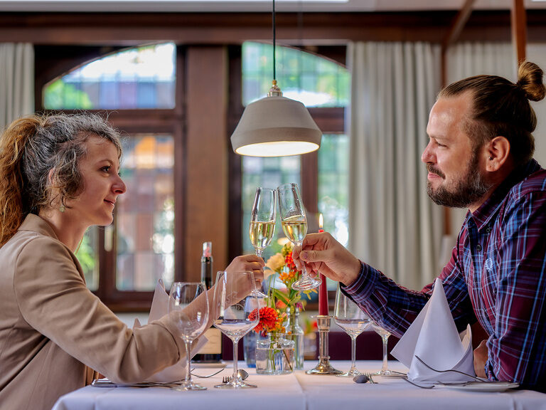 Paar stößt im Restaurant des Ringhotel Gasthof Hasen in Herrenberg mit Sekt auf einen genussvollen Abend an